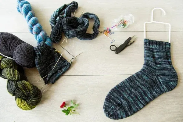 Knitting set and knitted socks on a white background