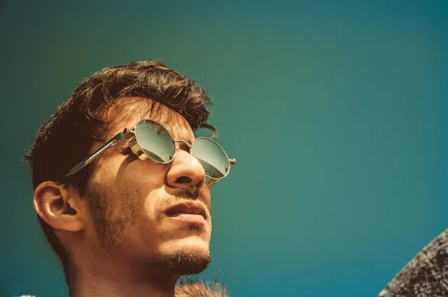 a person wearing sunglasses with round lenses for how to tell if sunglasses have uv protection