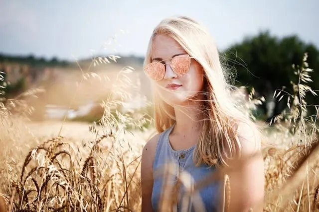 a person wearing sunglasses in a wheat field for how to tell if sunglasses have uv protection